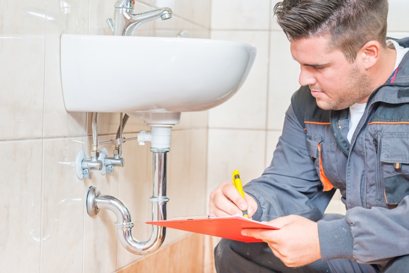 Do I Need a Plumbing Inspection? Young Plumber With Clip Board.